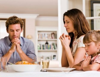 Family praying at dining room table Copy